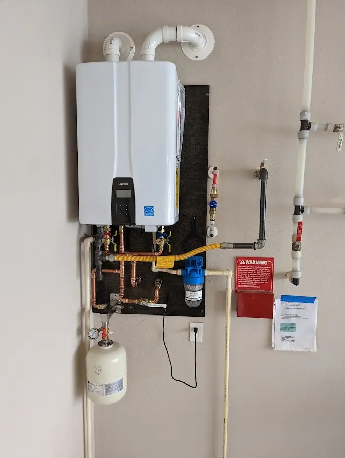 Professional plumber installing copper piping in a Bunk Foss home